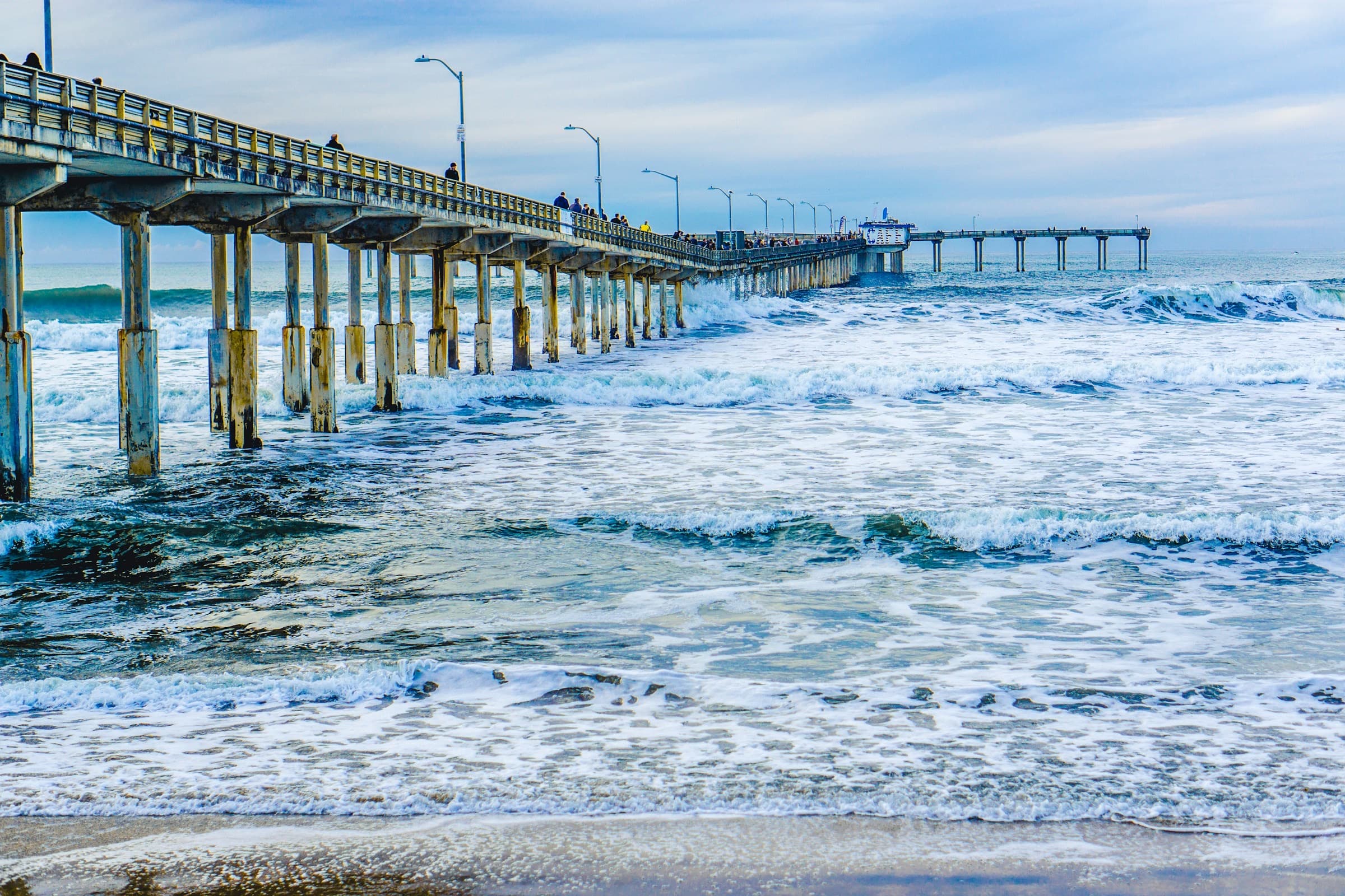 Ocean Beach Pier at sunset with surfers in the water